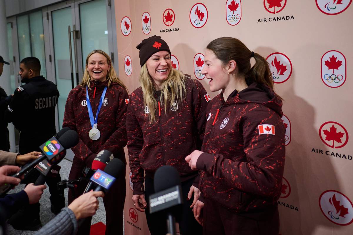 Canadian ice hockey players Renata Fast, left to right, Natalie Spooner and Ella Shelton speak with media at Pearson Airport in Toronto, on Monday, Feb. 23, 2026.