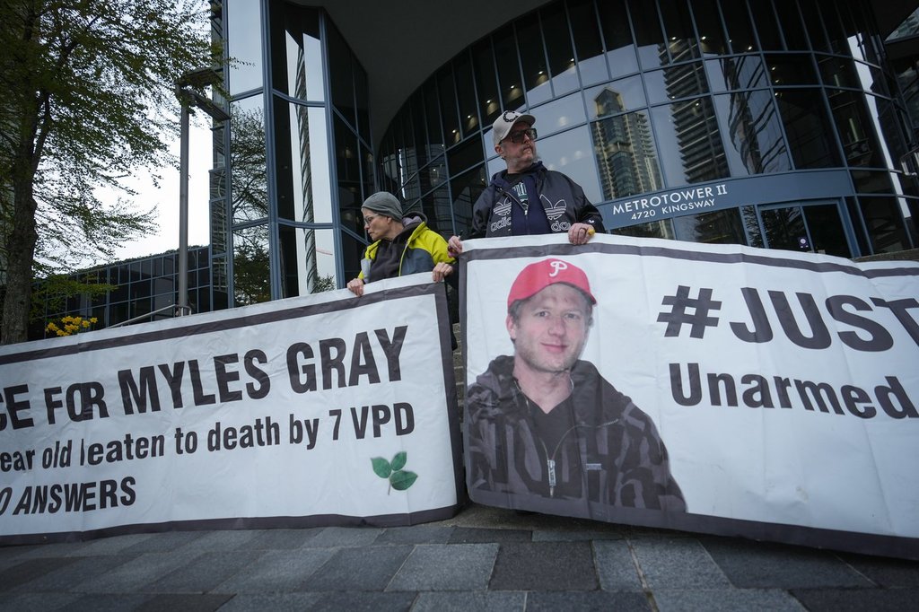 Protesters hold banners with a photograph of Myles Gray, who died following a confrontation with several police officers in 2015, before the start of a coroner's inquest into his death, in Burnaby, B.C., on Monday, April 17, 2023. THE CANADIAN PRESS/Darryl Dyck.